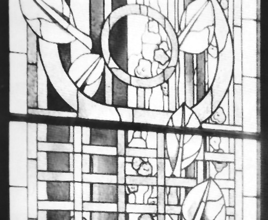 Historisches Fenster mit floralen Glaselementen im Büro.